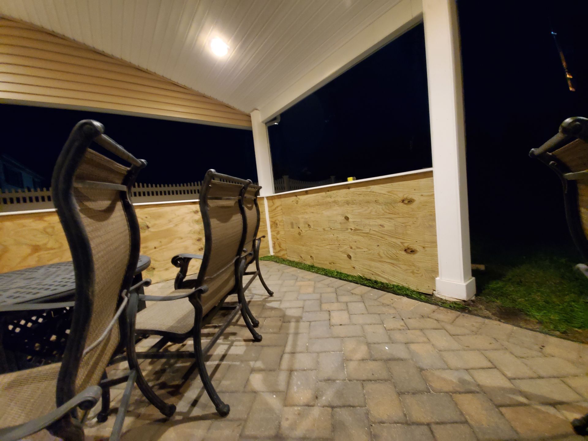 A patio with a table and chairs at night
