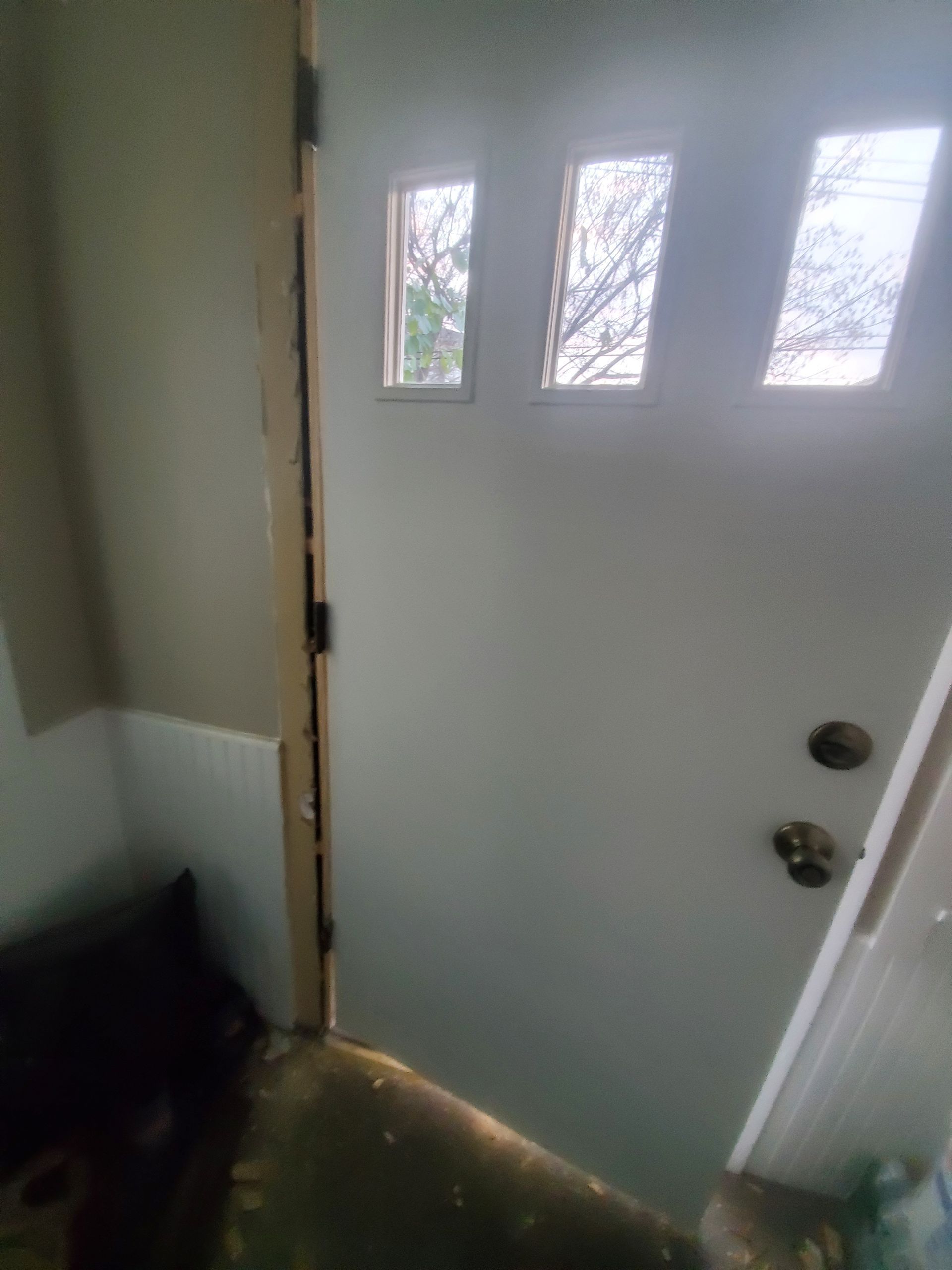 A white door with three windows in a room.