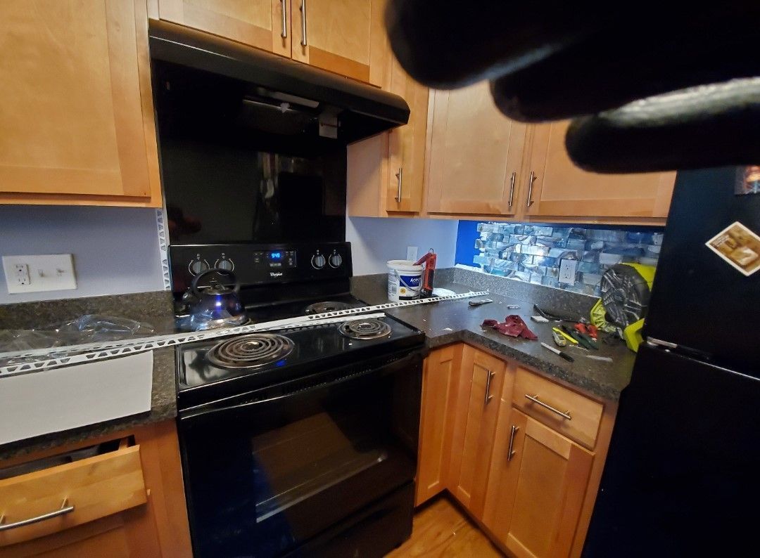 A kitchen with wooden cabinets , a black stove , and a black refrigerator.