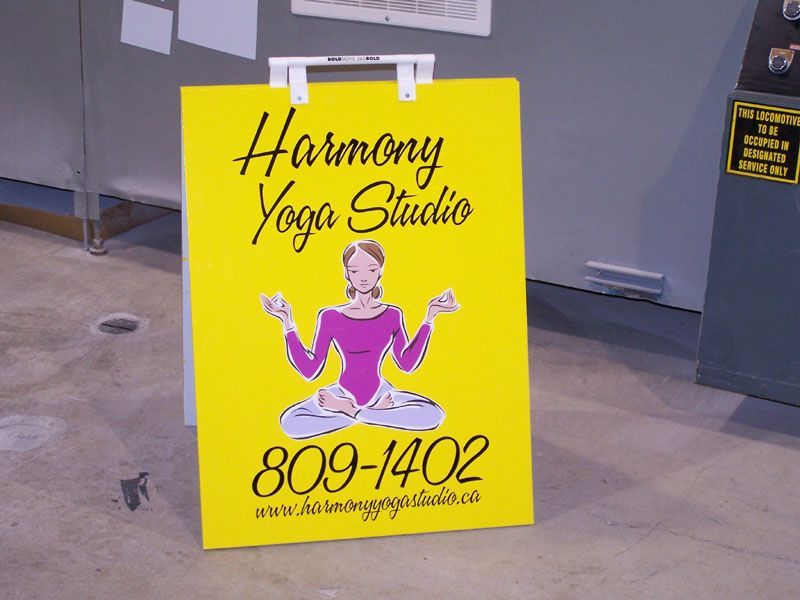 A yellow sign that says harmony yoga studio on it