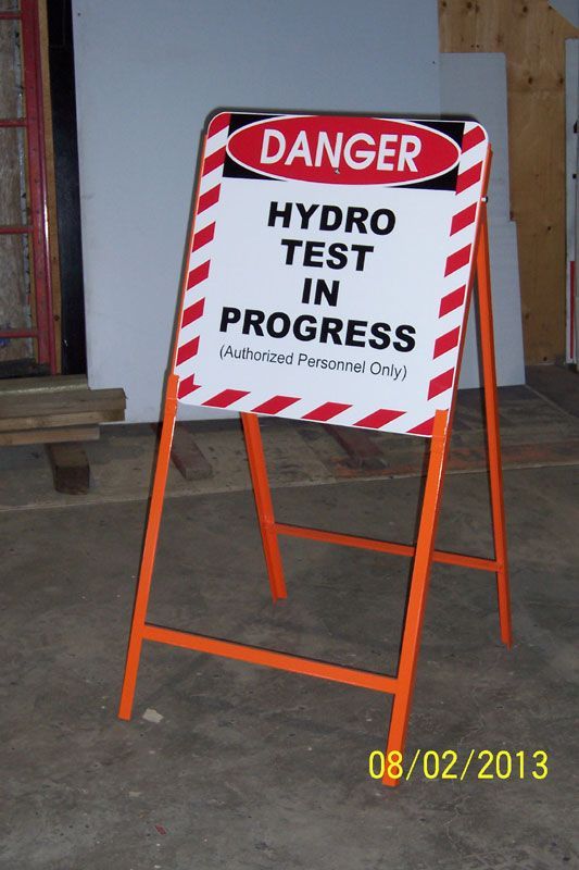 Orange A-frame sign with red and white diagonal stripes, reading 