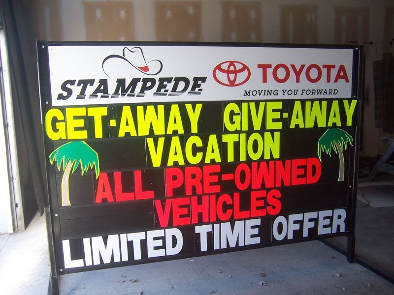 A sign that says stampede toyota get away give away vacation all pre-owned vehicles limited time offer