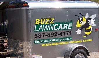 A trailer with buzz lawncare written on it