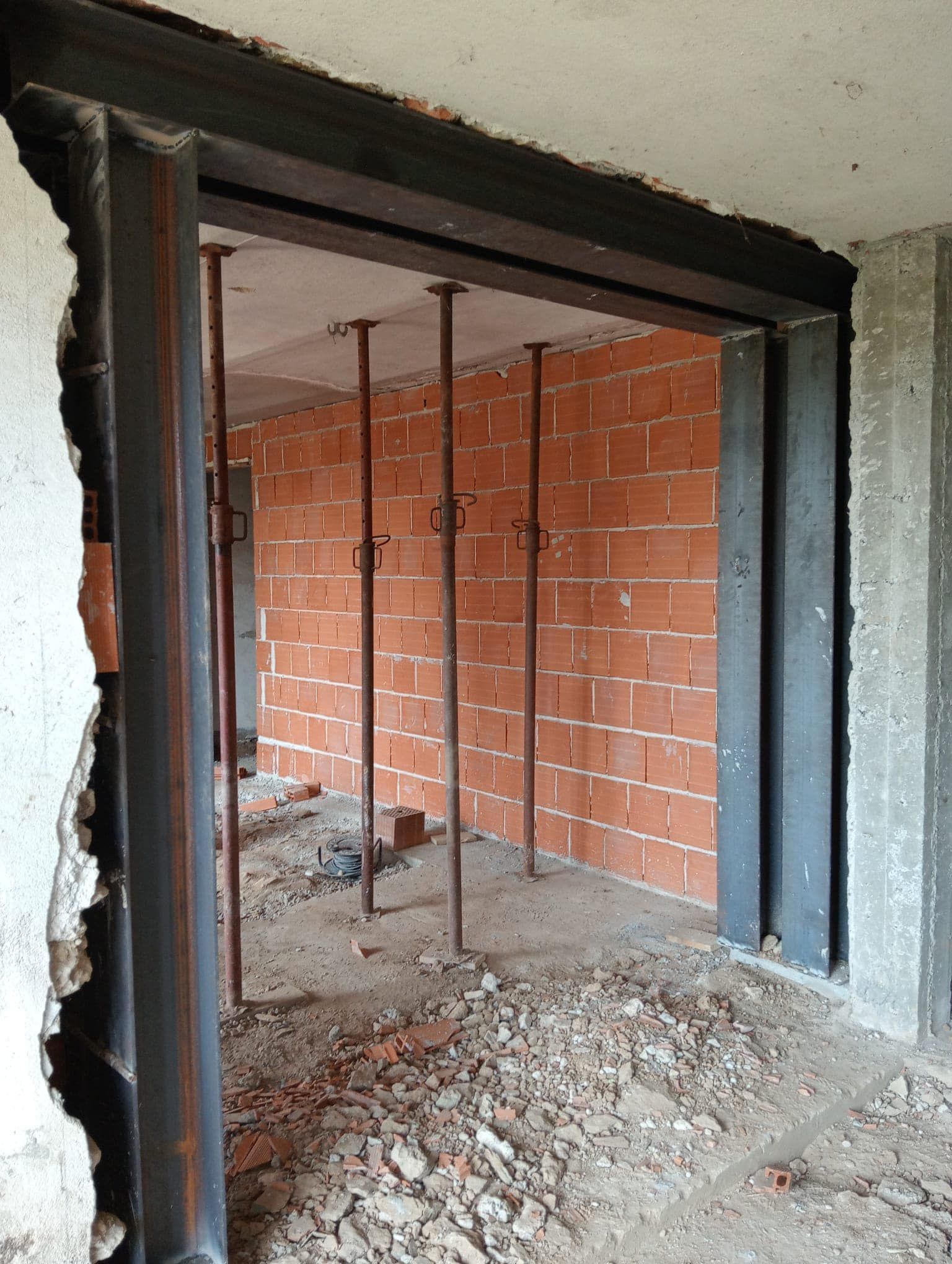 Una stanza in costruzione con pareti in mattoni e una struttura in metallo