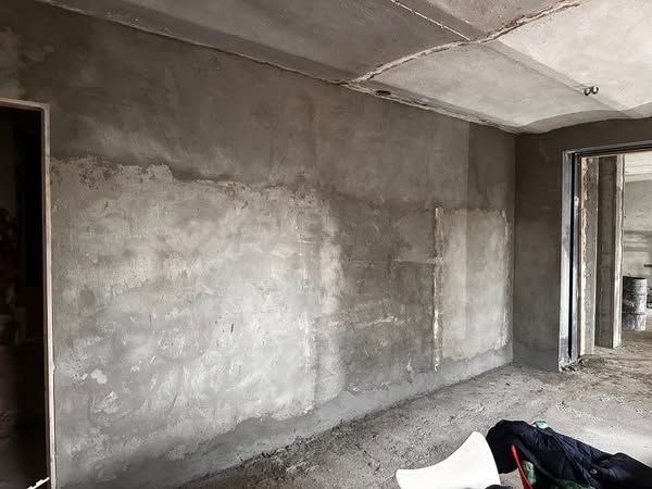 Una stanza con un muro di cemento e una porta.