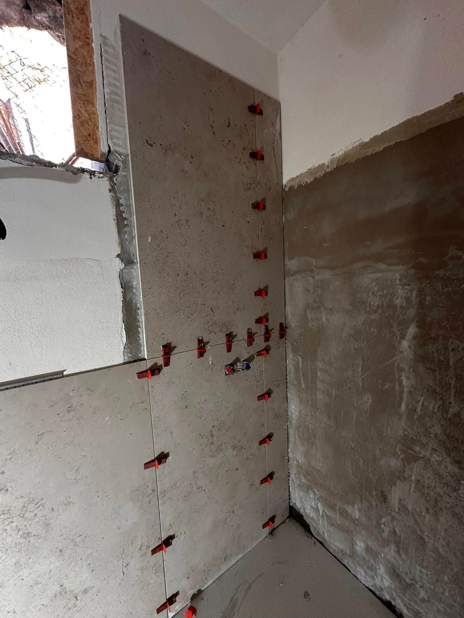 Un angolo di una stanza con piastrelle installate sul muro.