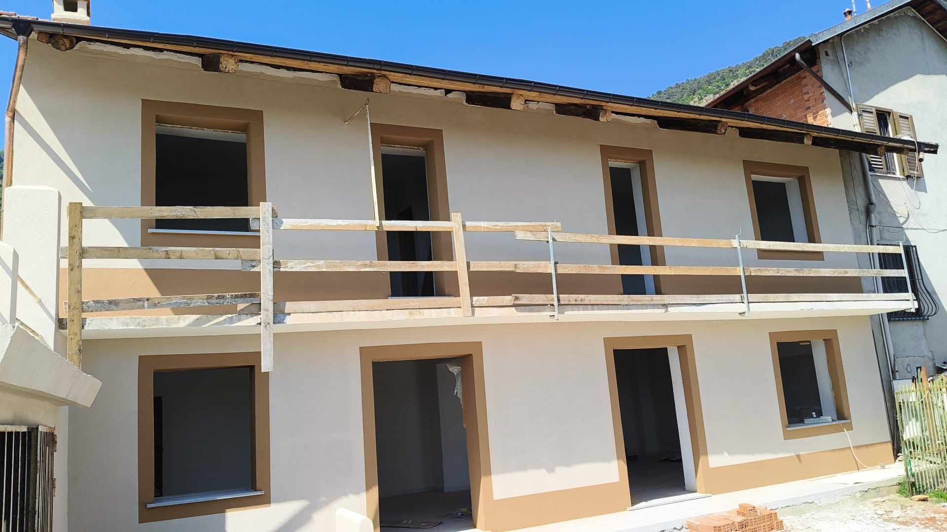 Una casa con un balcone e una ringhiera di legno