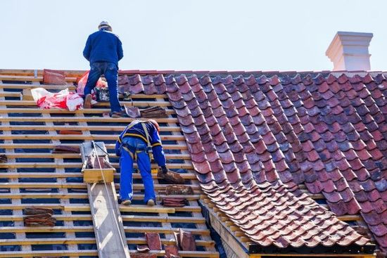 An image of roofing contractors adding slate tile roofs for roof replacement services in Royal Palm Beach FL