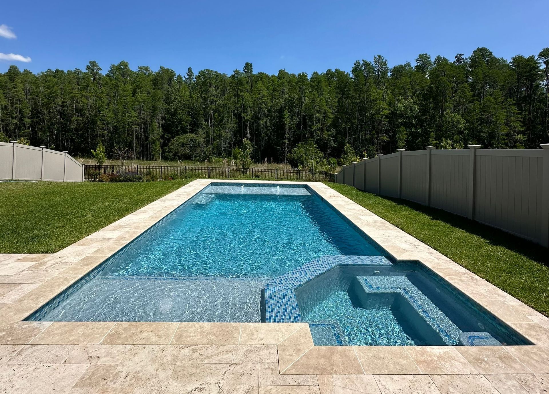 A large refinished swimming pool surrounded by grass and trees