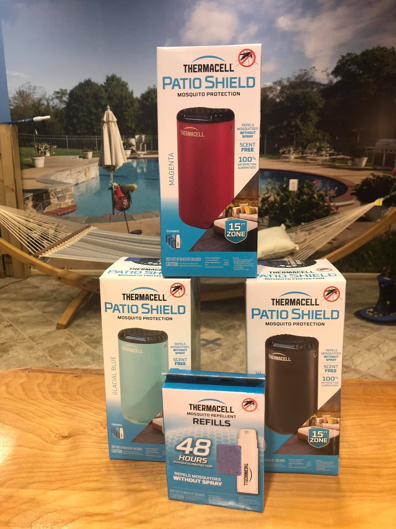 Stacked boxes of Thermacell Patio Shield mosquito repellent with a pool in the background.