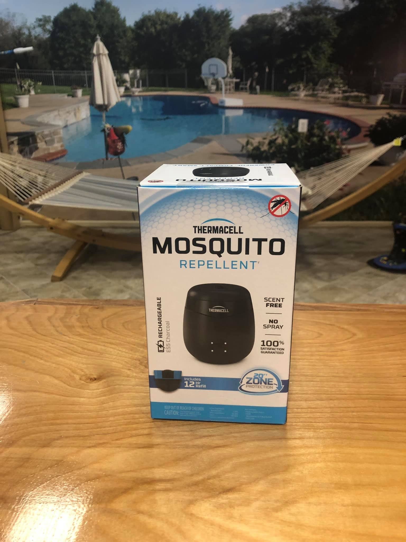 Box of mosquito repellent in front of a pool, with a black device pictured on the box.