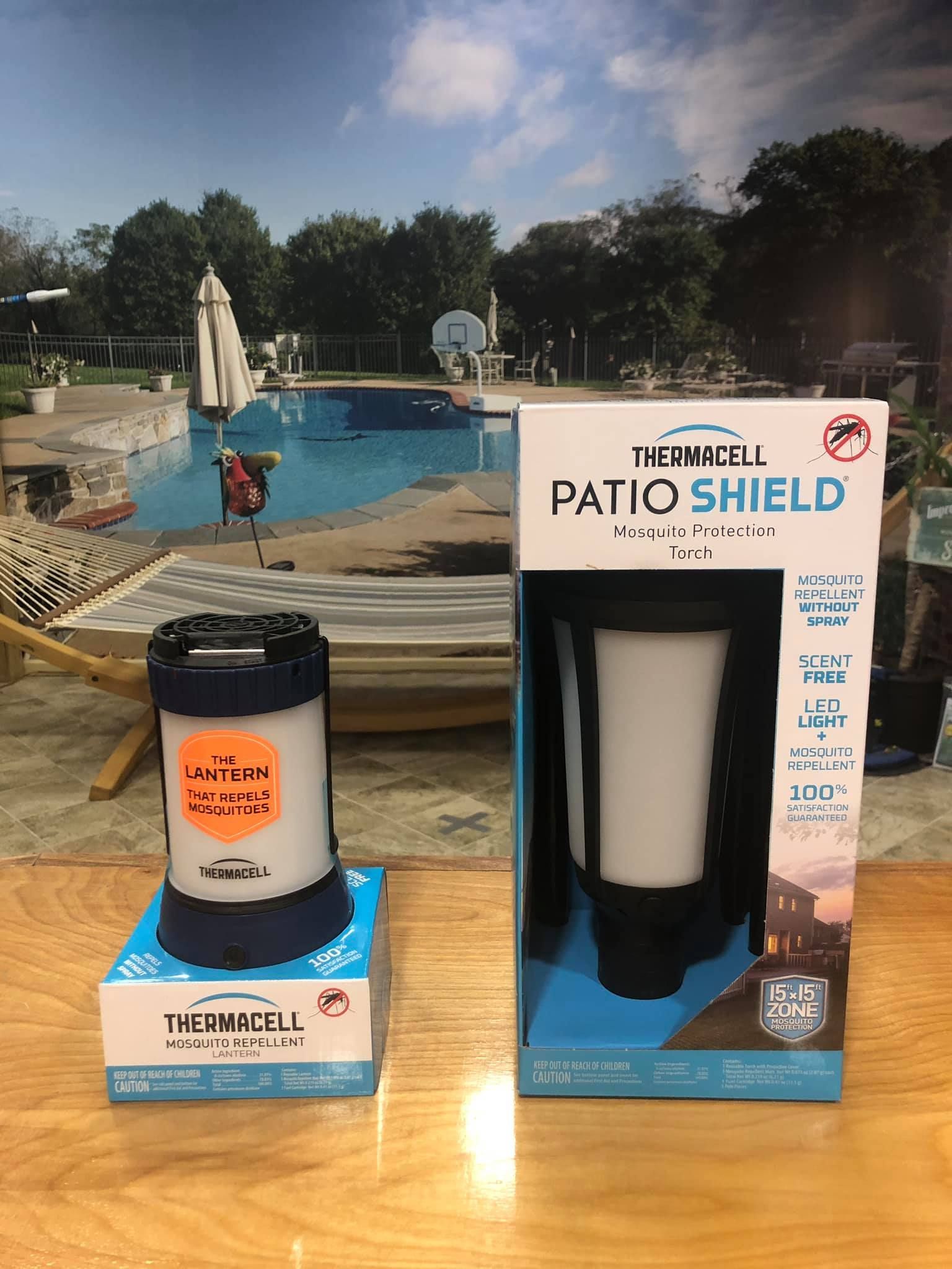 Two Thermacell Patio Shield mosquito repellent devices; one boxed, one in use, on a wood table, pool in background.