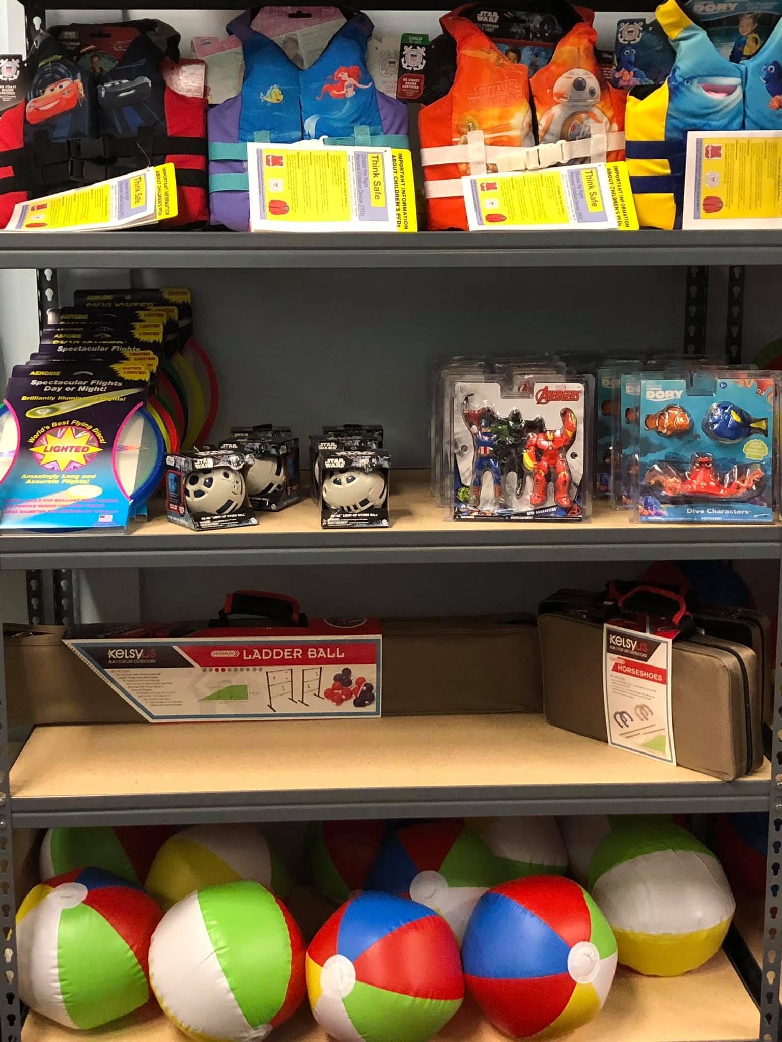 Shelves stocked with colorful life vests, toys, and beach balls.