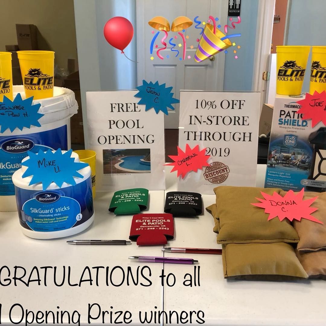 Table with pool supplies, signs for free pool opening and 10% off. Balloons and confetti.