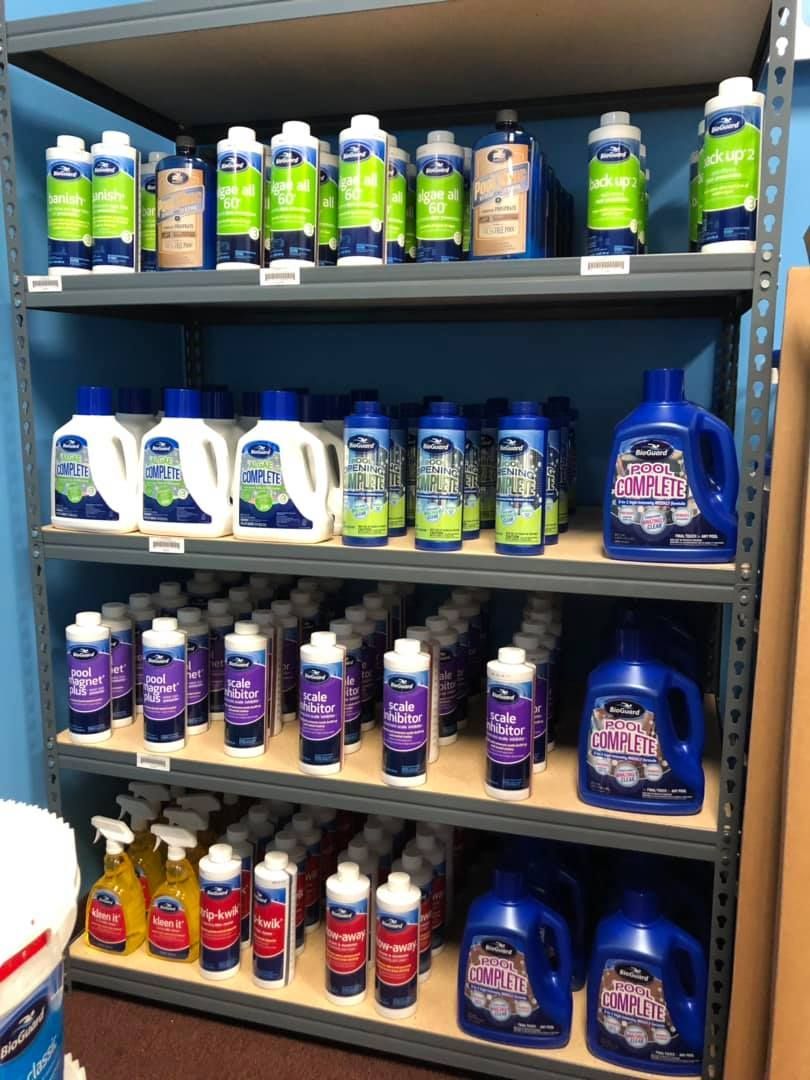 Shelves stocked with various laundry detergents in blue, white, green, and red bottles.