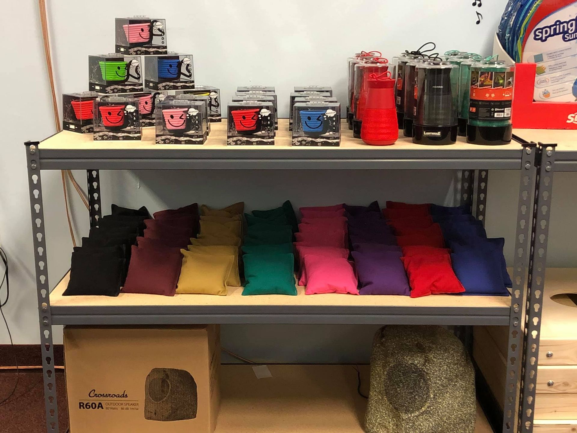 Shelves displaying various colorful items: boxes with face designs, and beanbags.