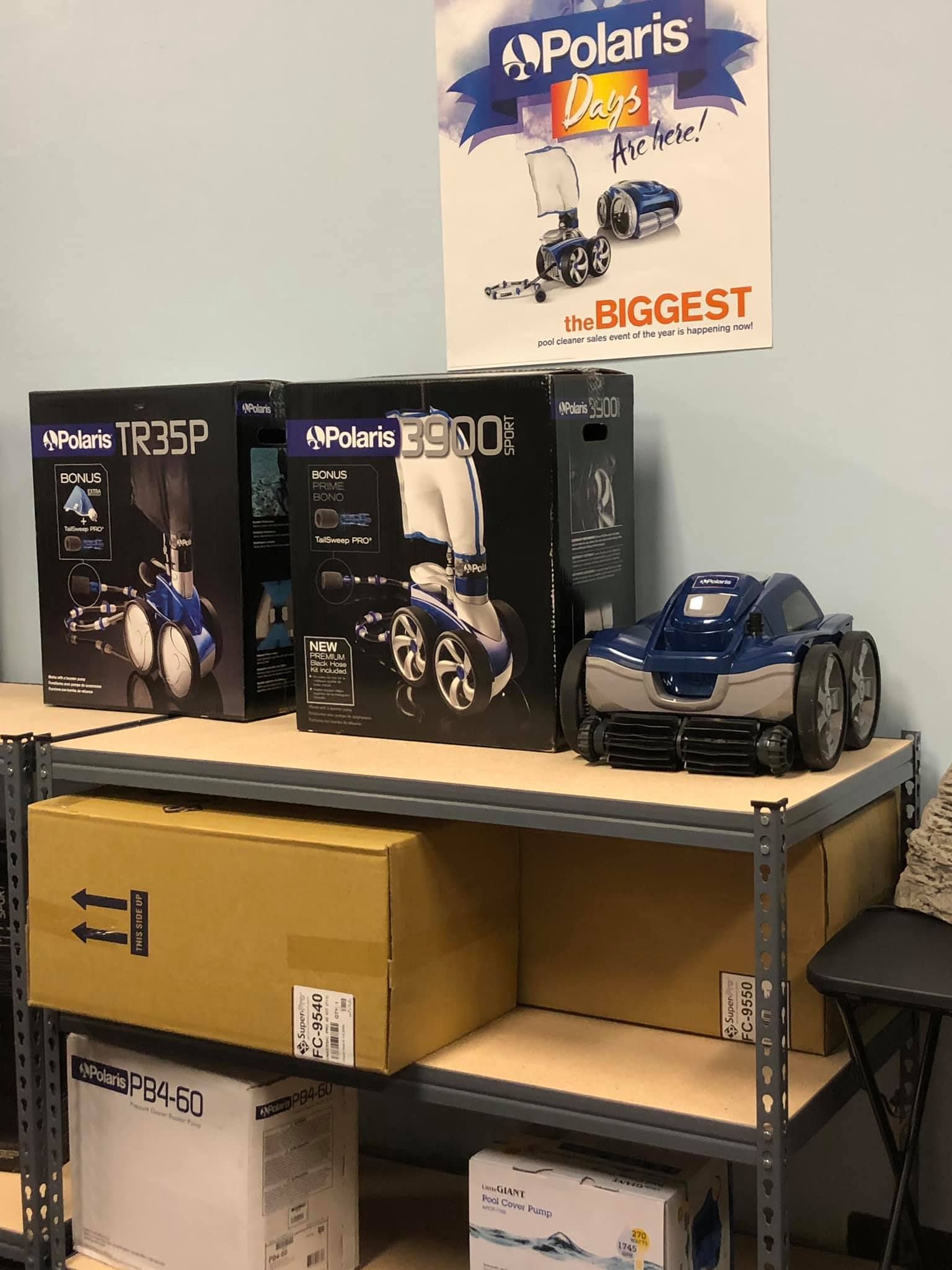 Shelves with Polaris boxes, a blue toy car, and a Polaris poster.