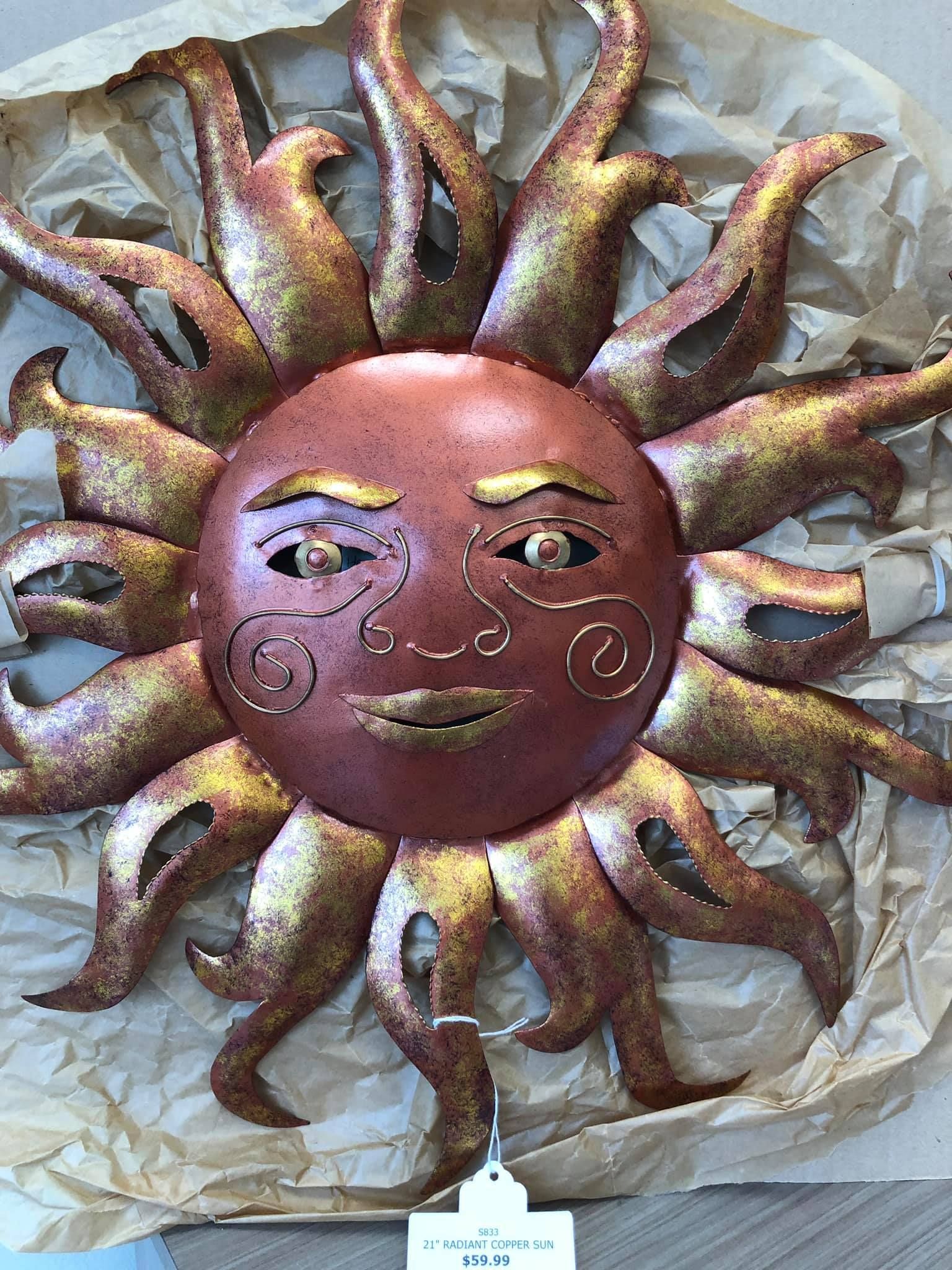 Metal sun face wall decor with reddish-brown and gold accents.