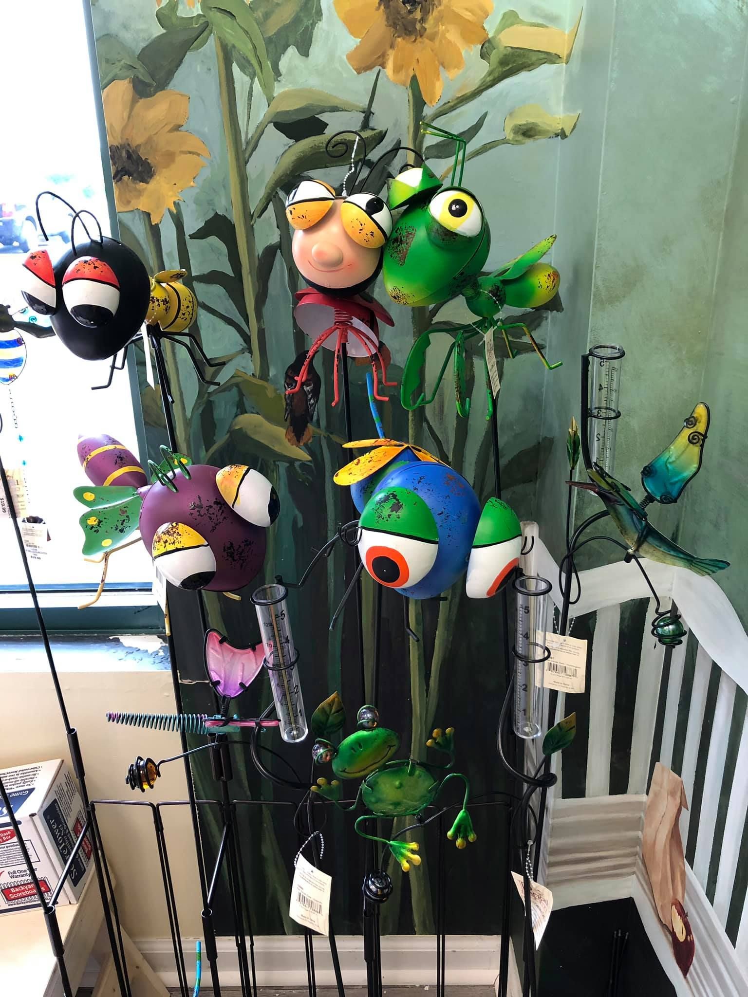 Metal garden art display featuring colorful bug-like sculptures.  