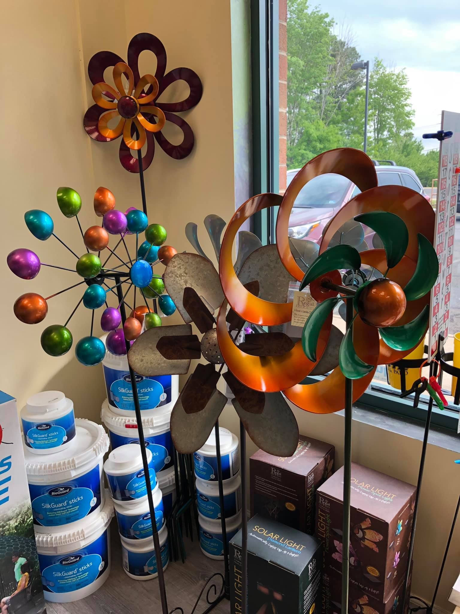 Metal wind spinners in a store display with paint cans.