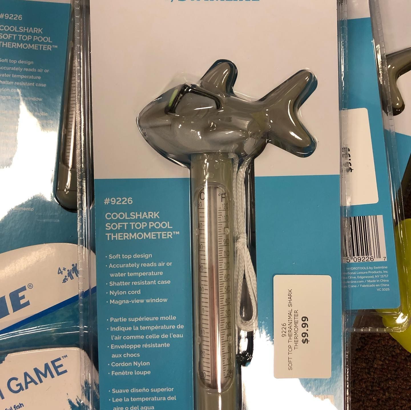 Shark-shaped pool thermometer in packaging, labeled with price.