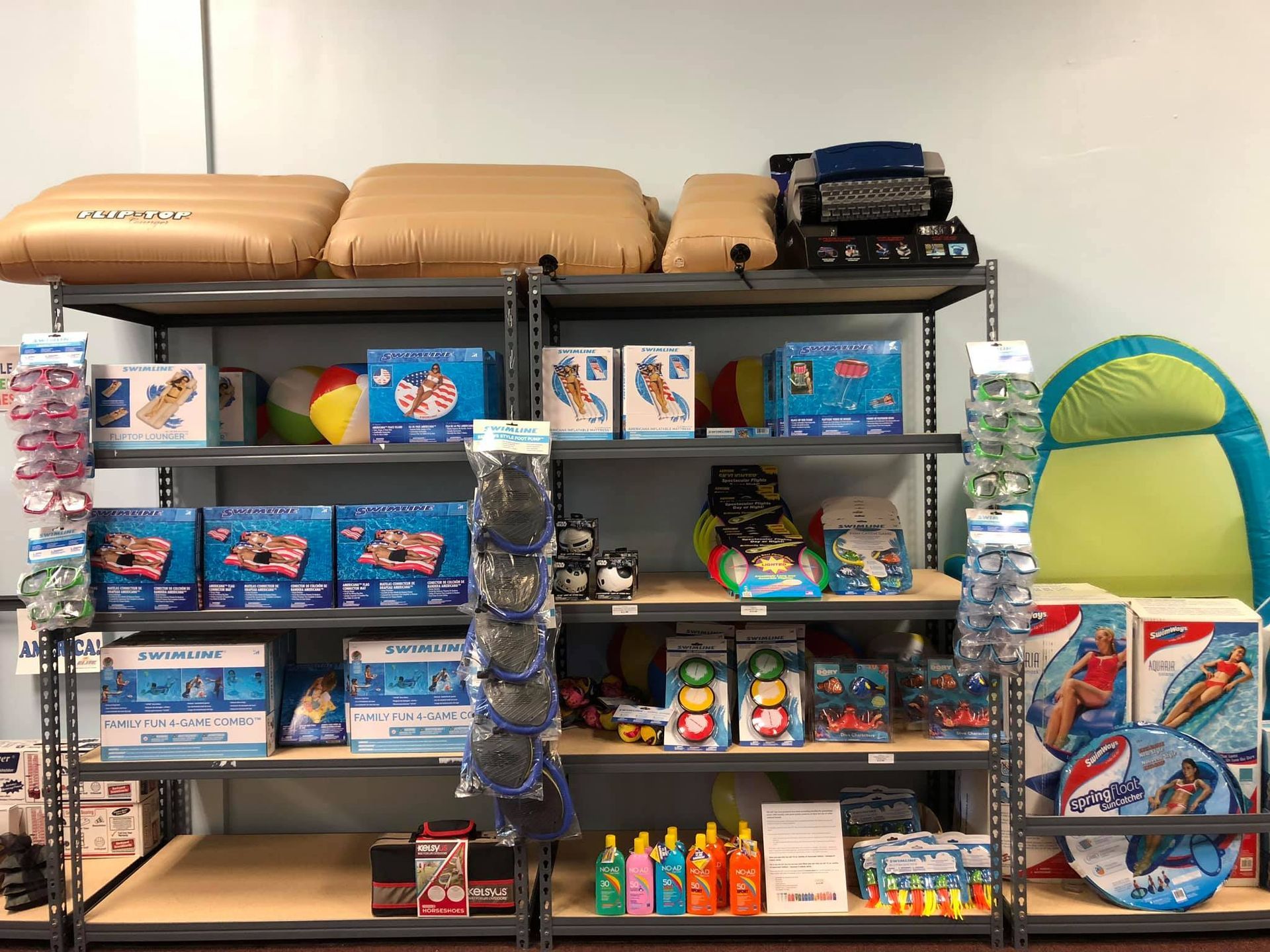 Shelves stocked with inflatable pool toys and accessories in a store.