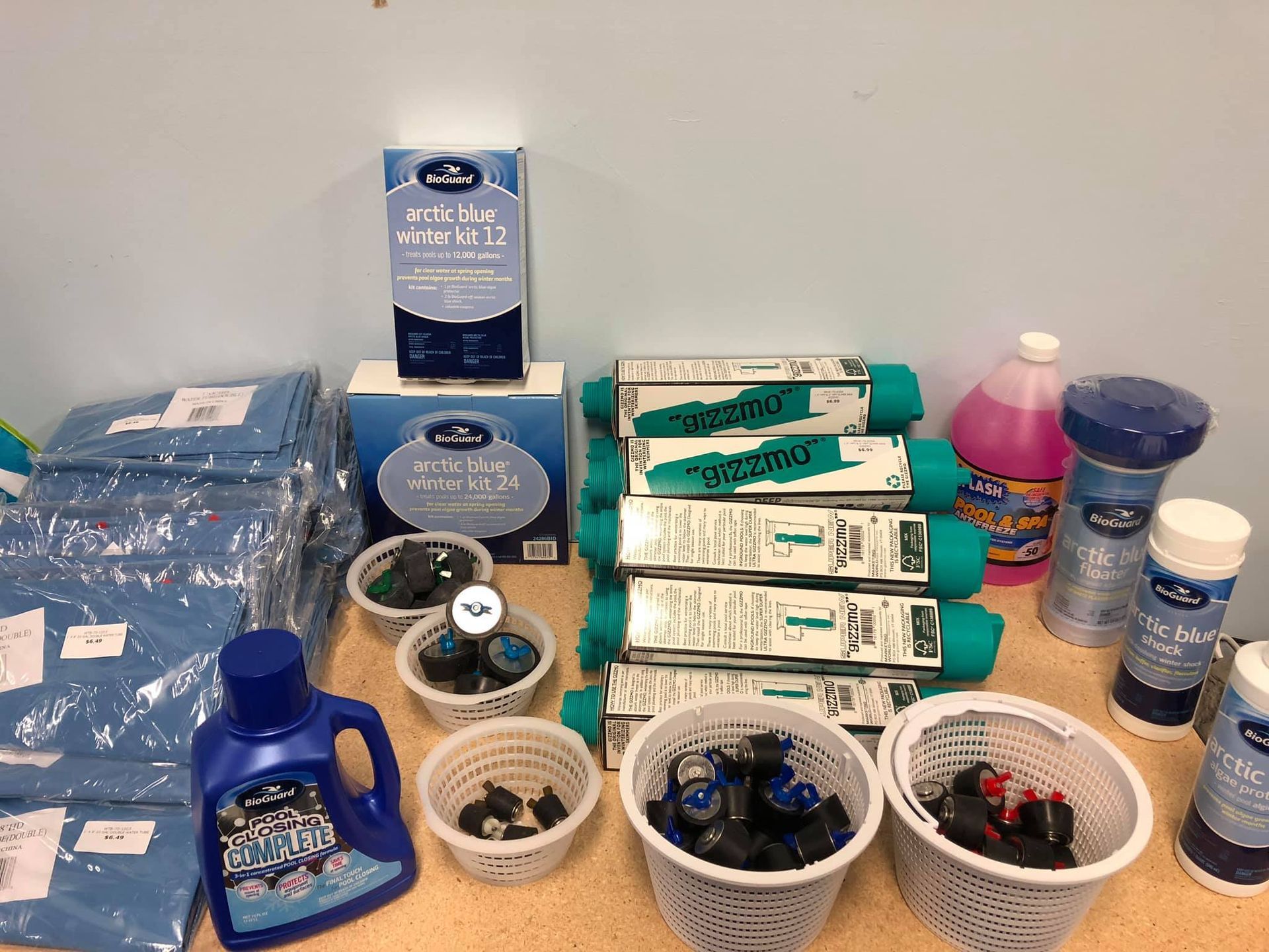 Pool supplies: chemicals, filters, and parts arranged on a counter.
