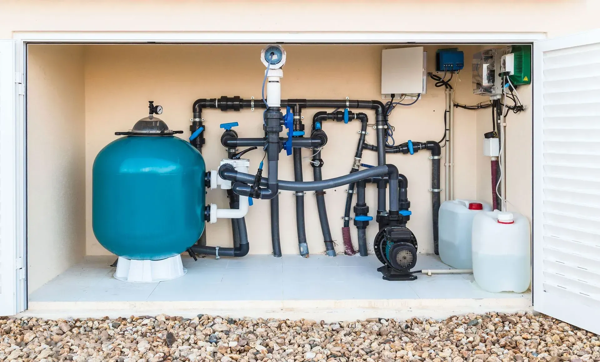 Poolside with waterfall, chemicals, and equipment for water maintenance.