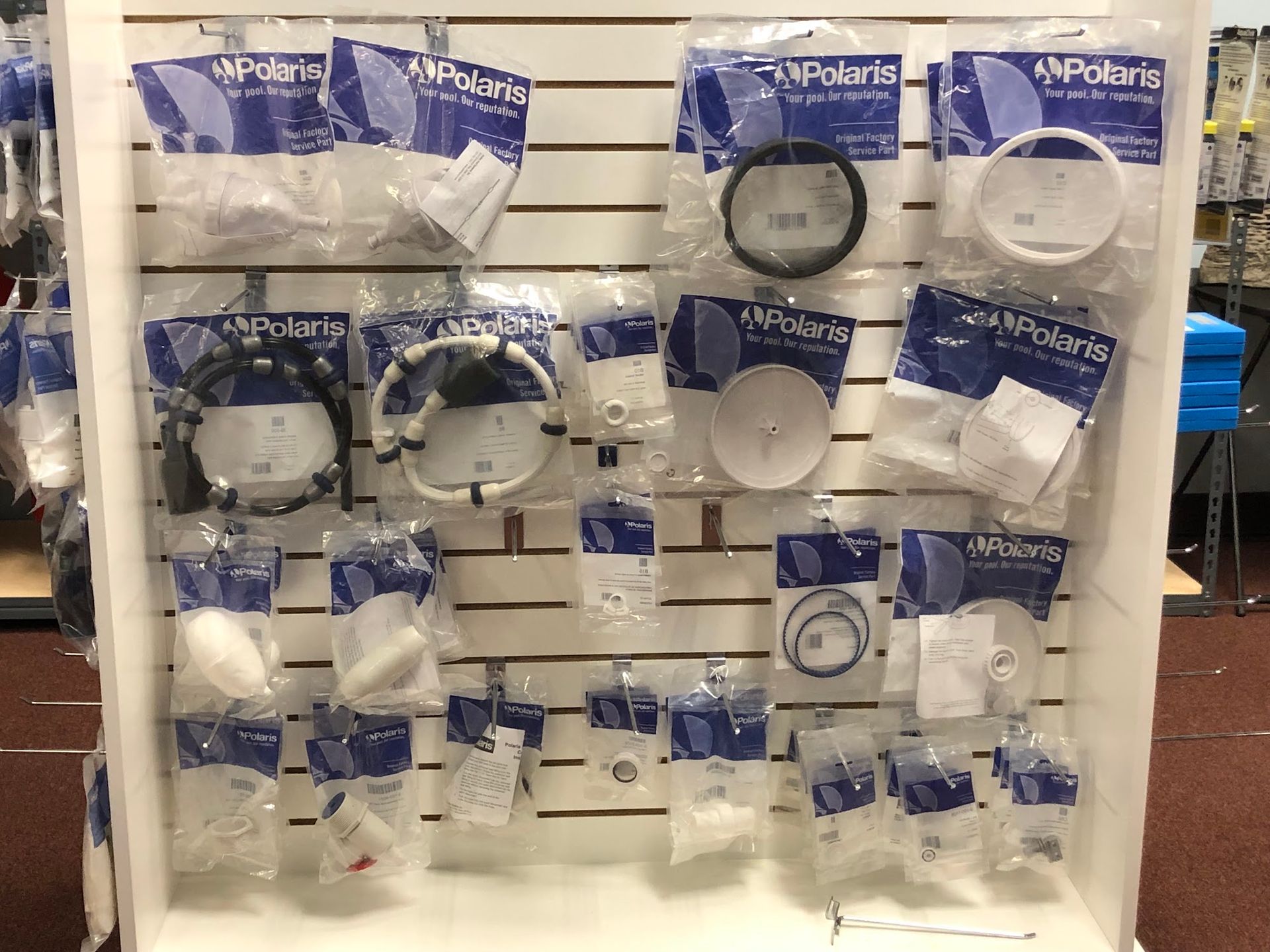 Display of Polaris parts in clear packaging on a white retail shelf.