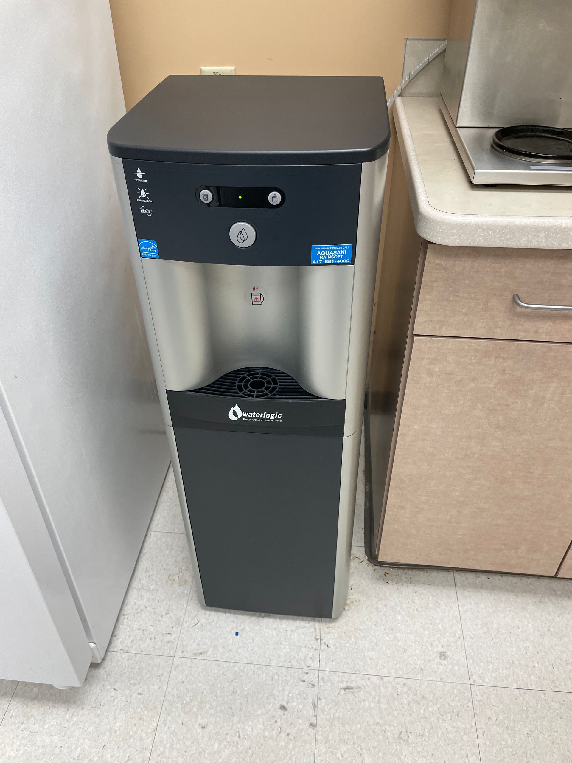 A group of blue tanks sitting next to each other in a factory.
