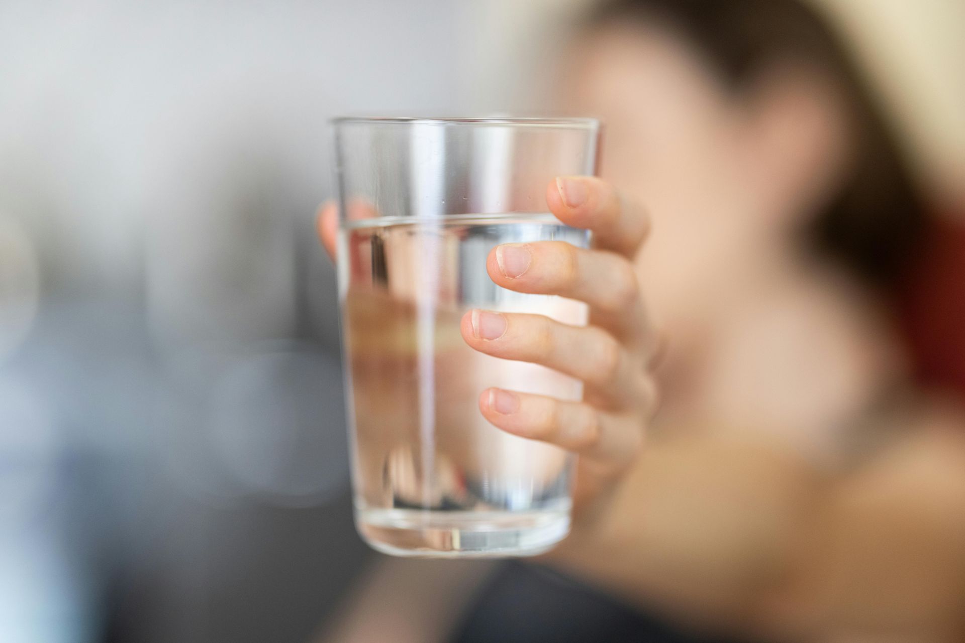 Person holding glass of drinking water.