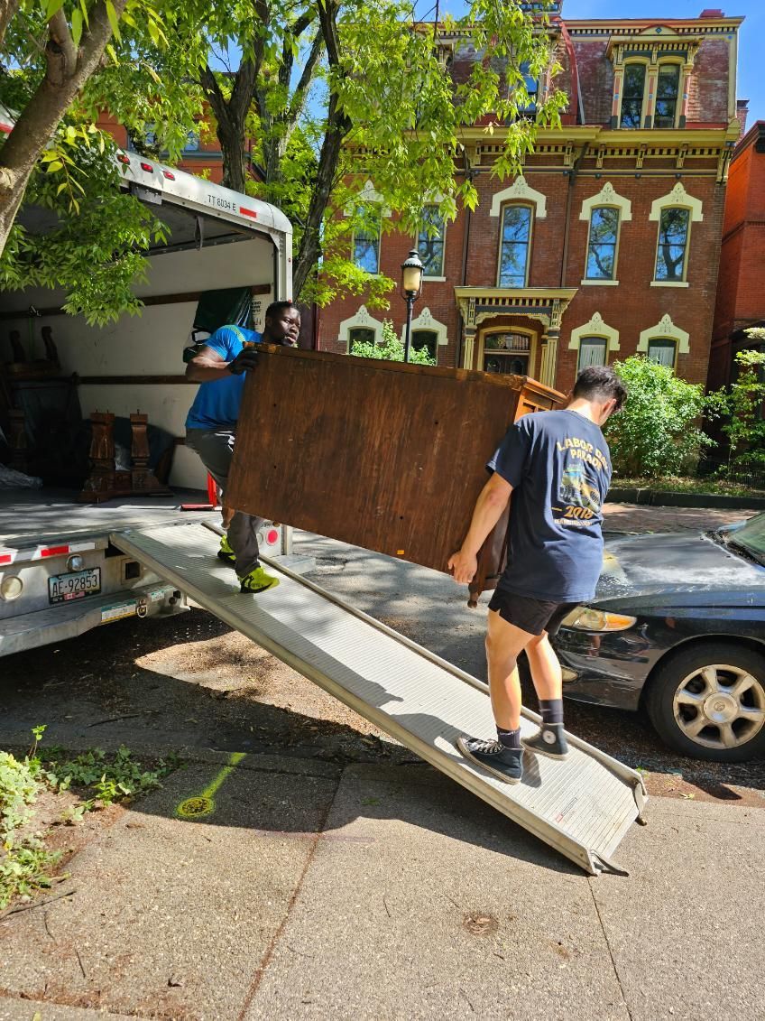 A man is carrying a large piece of wood on a ramp.