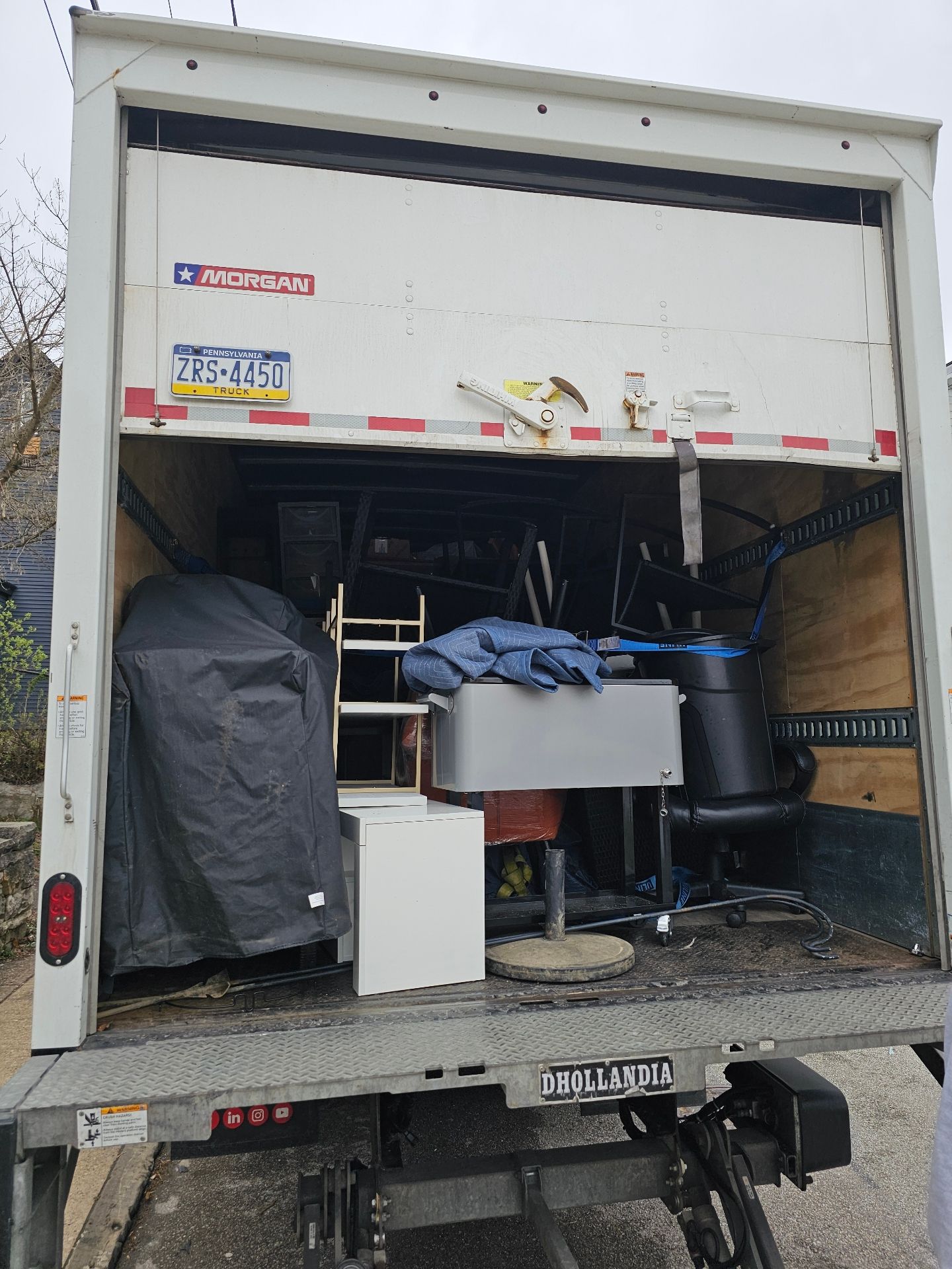 The back of a moving truck is filled with furniture.