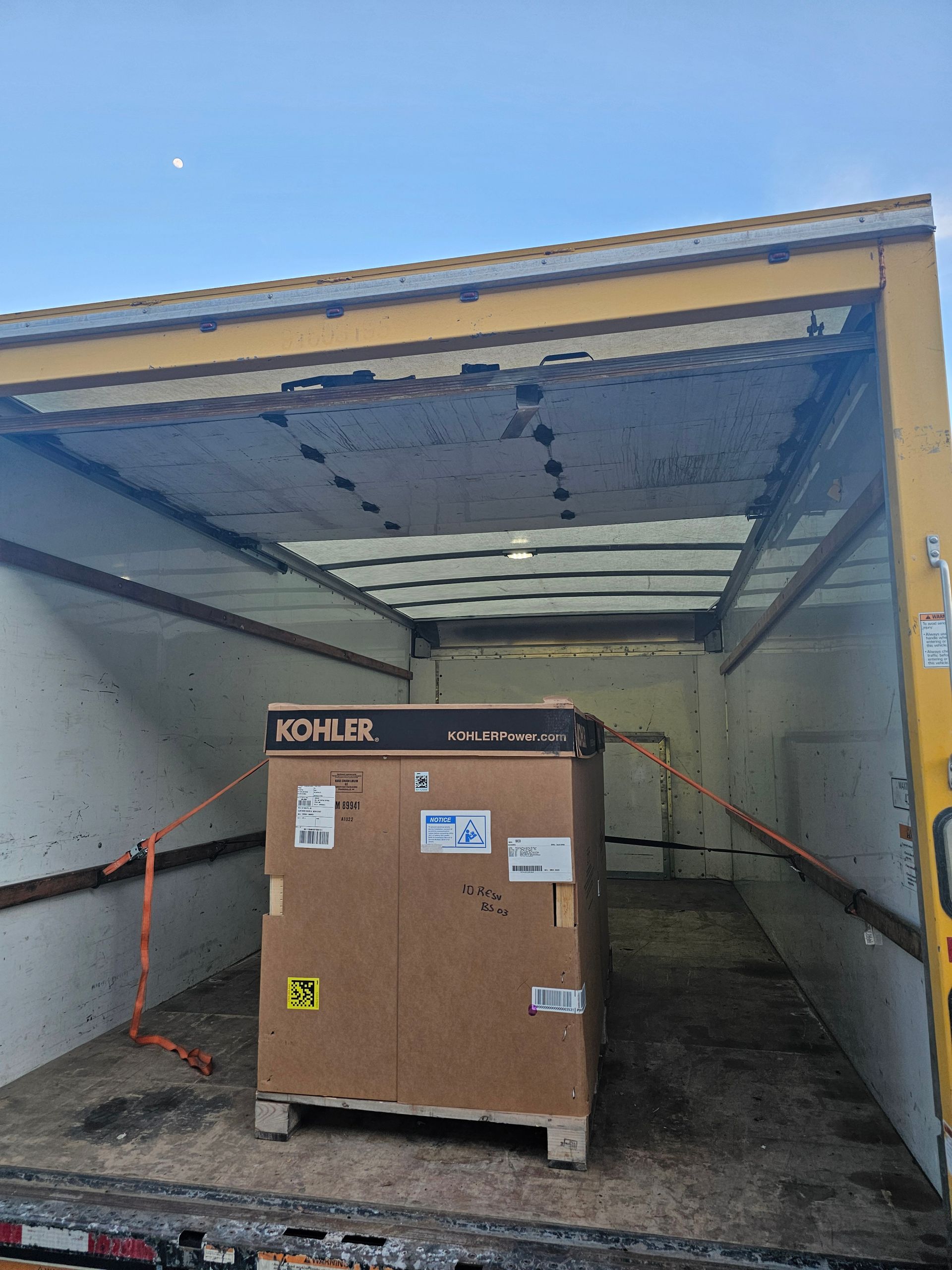 A large box is sitting in the back of a truck.