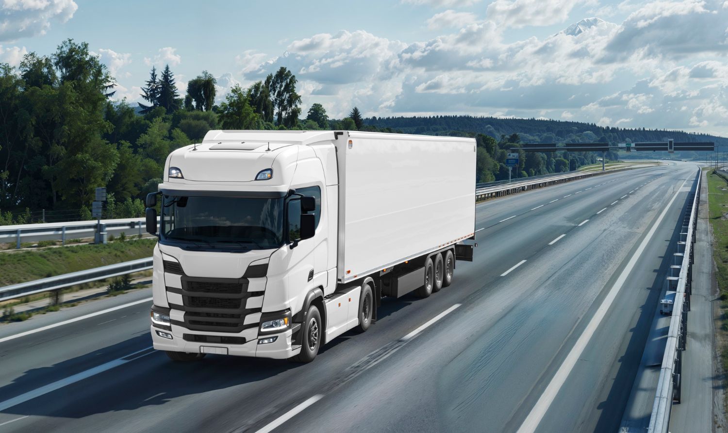 White semi-truck driving on a highway on a sunny day, with trees in the background.