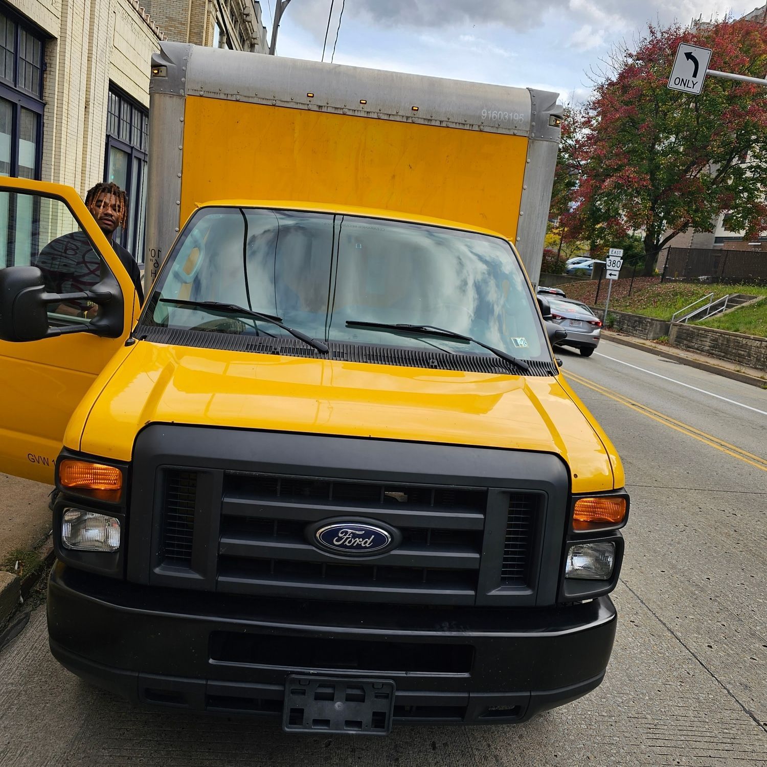 A yellow ford truck is parked on the side of the road