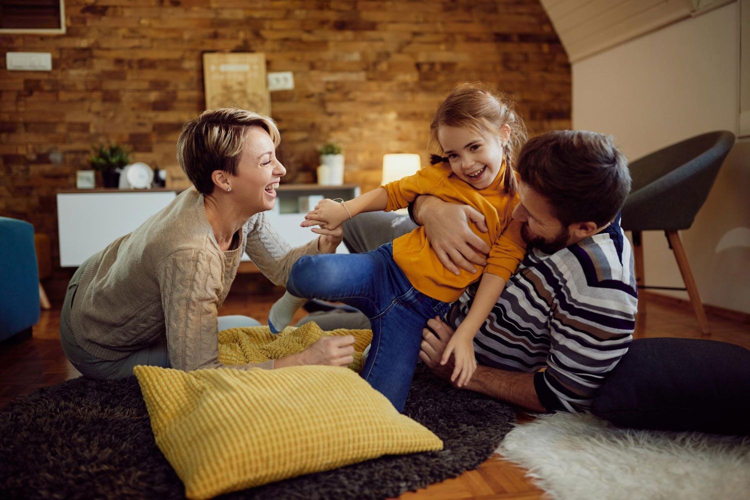 A family is playing on the floor in a living room.