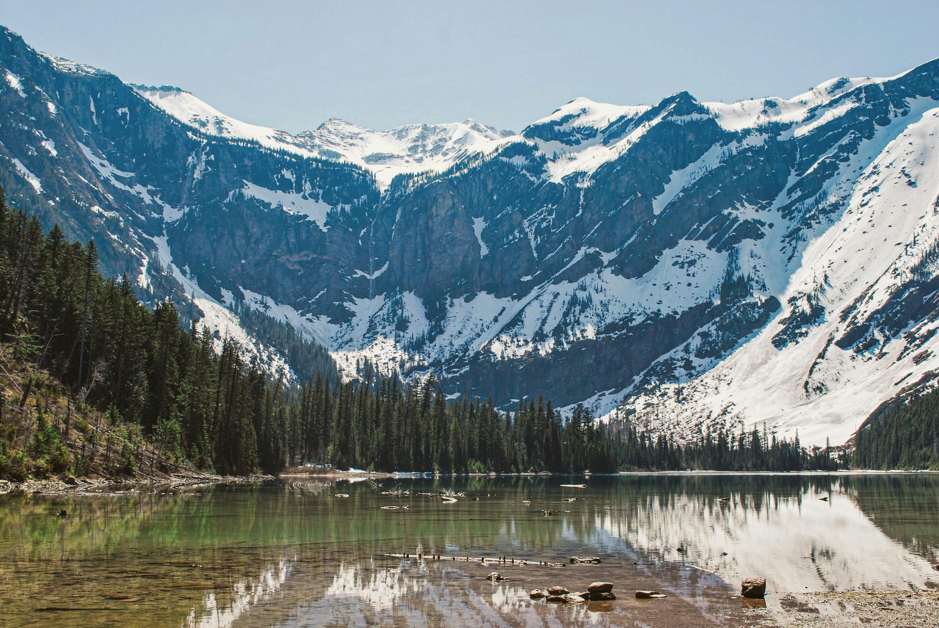 A lake surrounded by snow covered mountains and trees