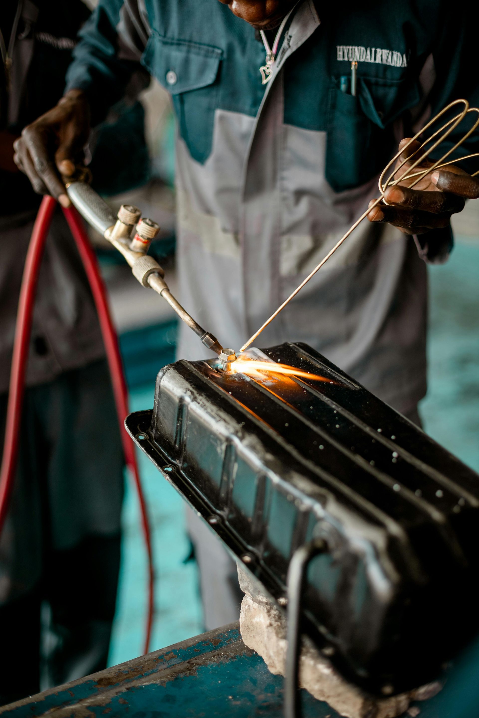 A man is welding a piece of metal with a torch.