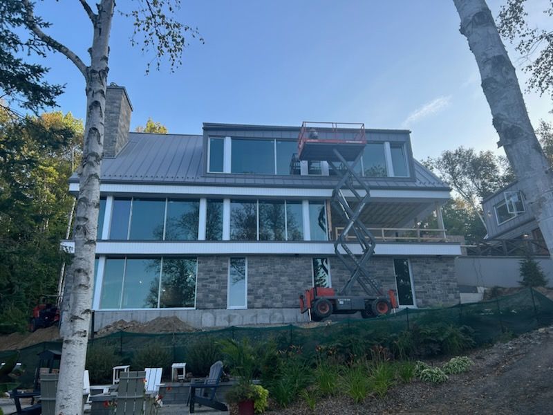 Une grande maison avec beaucoup de fenêtres est en construction