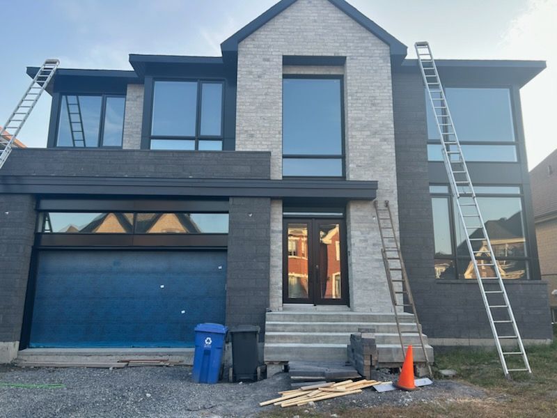 Une grande maison avec une porte de garage bleue est en construction