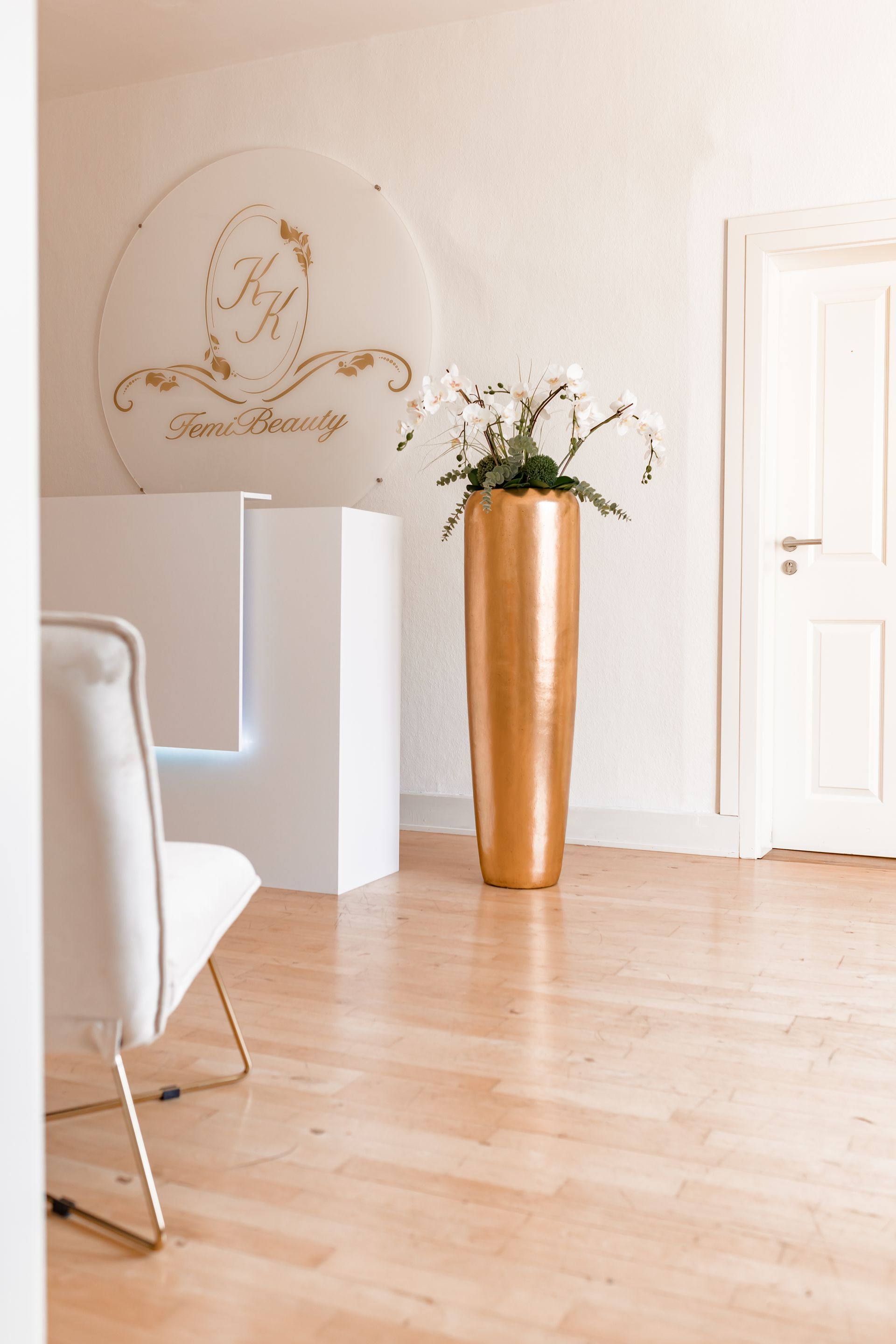 Ein Wartezimmer mit einem Stuhl und einer Vase mit Blumen