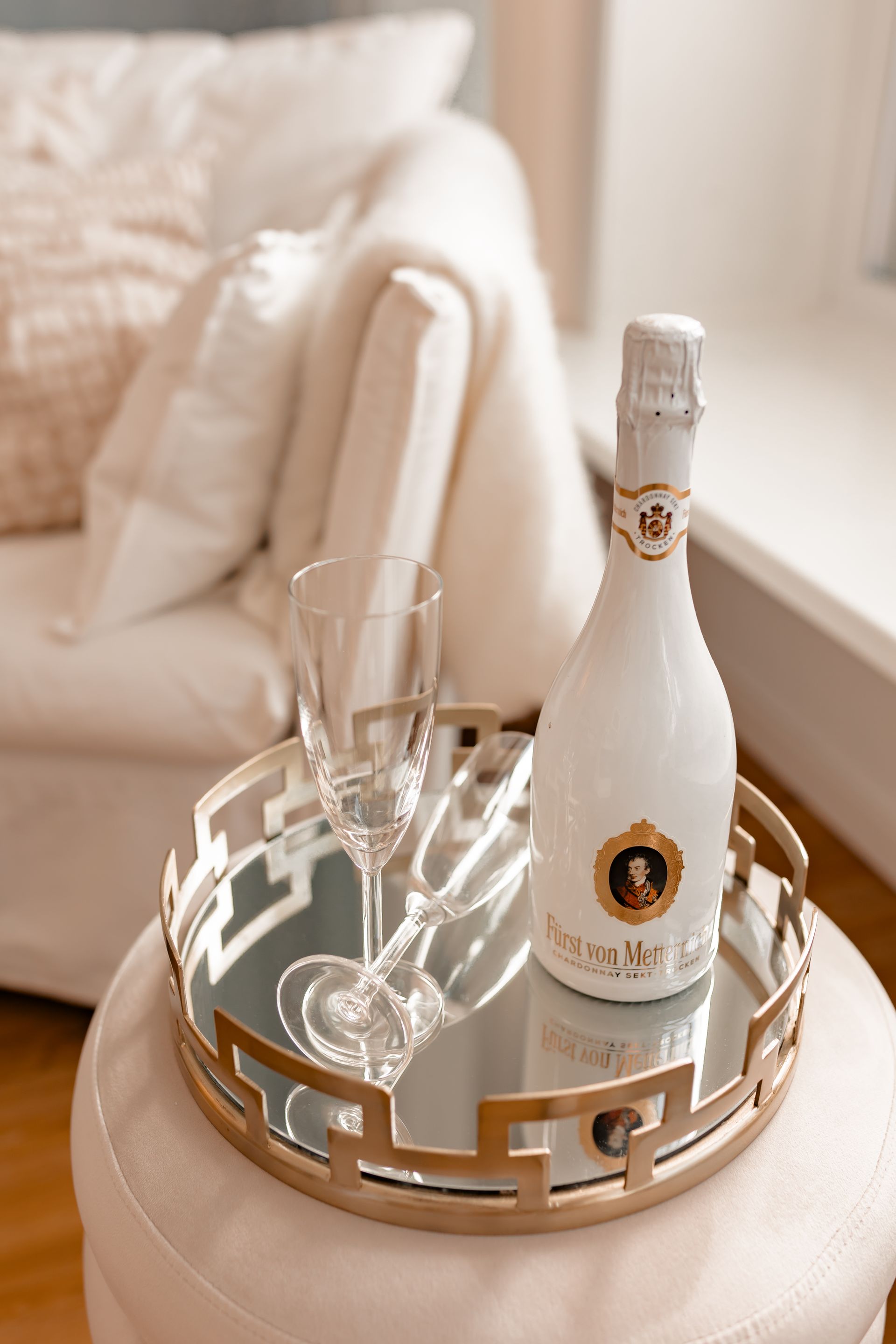 Eine Flasche Champagner und zwei Gläser stehen auf einem Tablett auf einem Tisch.