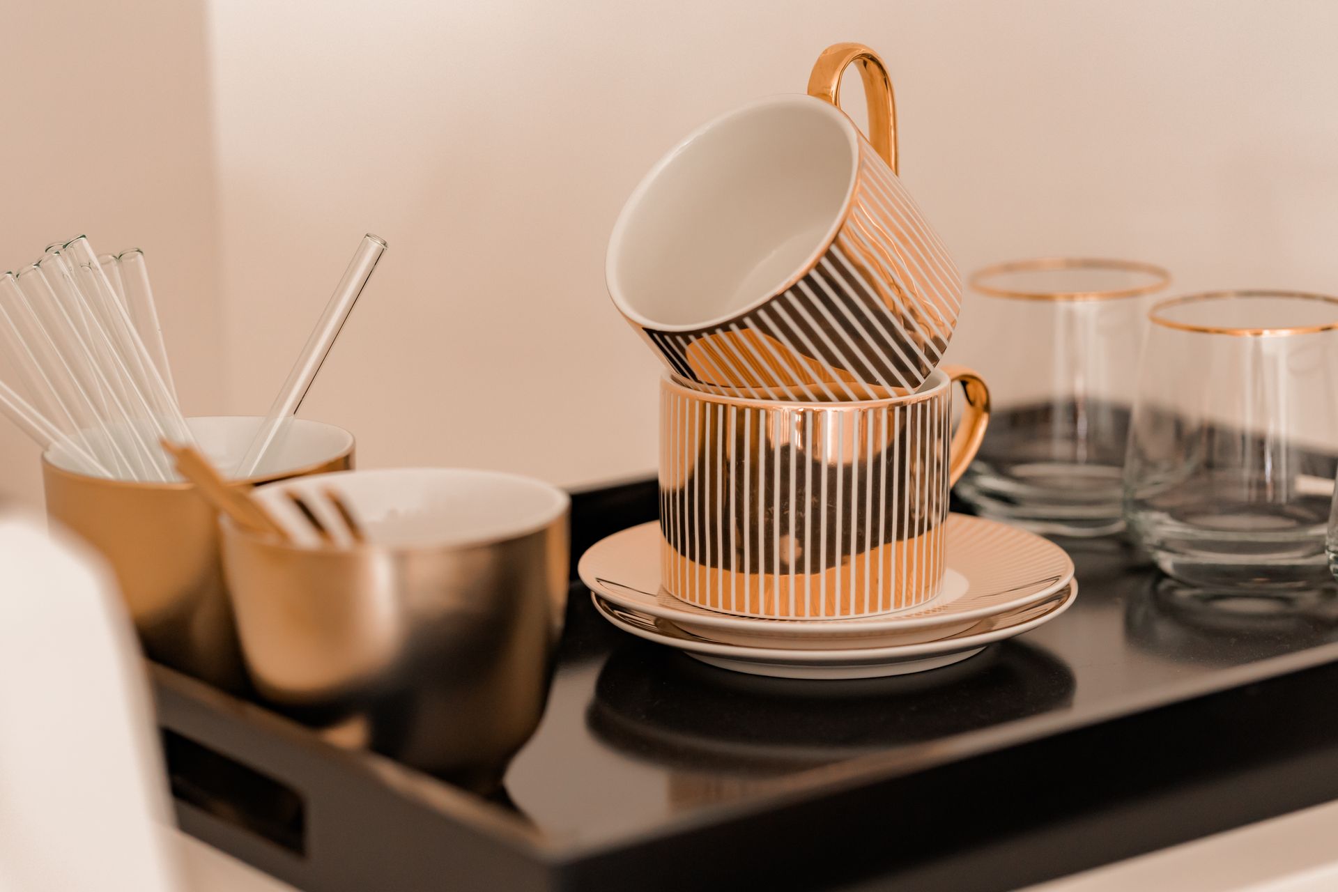 Ein schwarzes Tablett mit einem Stapel Kaffeetassen und Untertassen darauf.