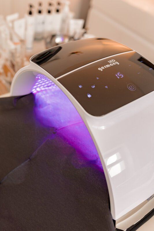 Auf einem Tisch steht ein weiß-schwarzes Gerät mit violetten Lichtern.