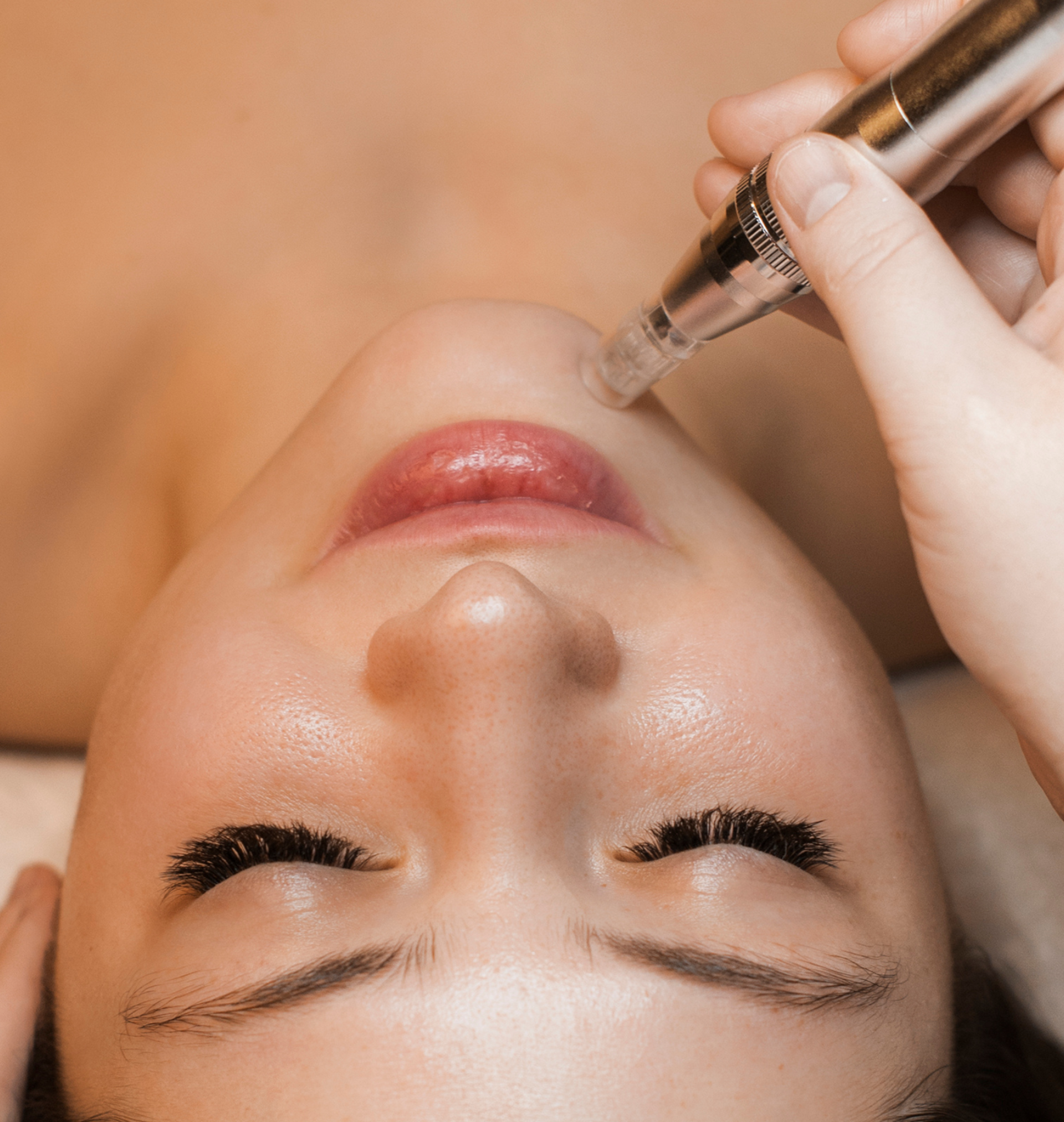 Eine Frau bekommt eine Gesichtsbehandlung mit einem Stift