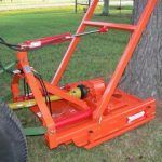 Orange tree stump grinder attached to a tractor.