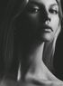 A black and white photo of a woman 's neck and face.