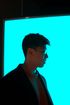 A man is standing in front of a blue screen.