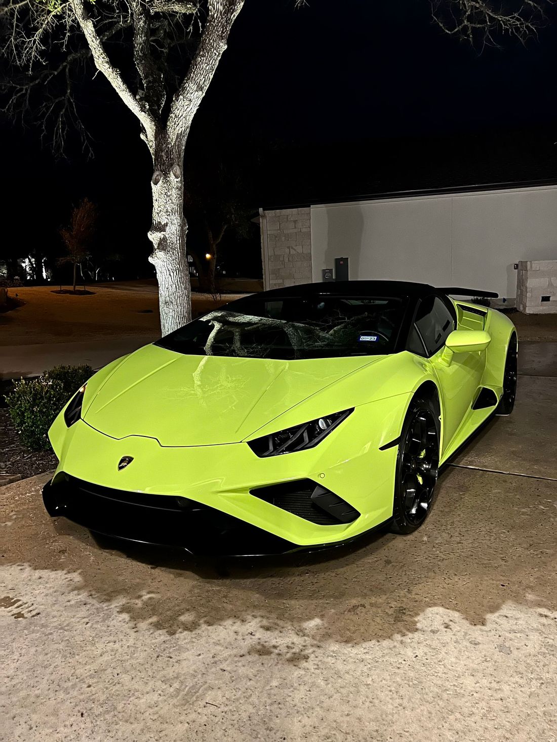 Neon green Lamborghini convertible parked at night.